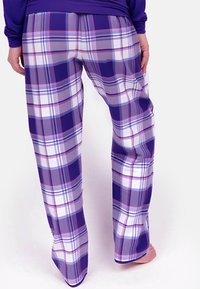 Paars geruite slaapbroek heeft een relaxte pasvorm, gemaakt van zachte stof met witte en lichtpaarse accenten in een ruitpatroon.