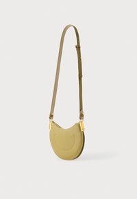 Oliwkowa torebka na ramię o zakrzywionym kształcie, gładkiej skórzanej fakturze oraz złotych akcentach metalowych. Regulowany pasek dla wygody.
