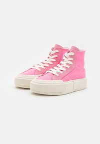 Sneakers typu high-top z jasnoróżową cholewką z płótna, białymi sznurówkami i masywną białą gumową podeszwą. Zawierają wykończenie zszywane oraz etykietę na tyle.
