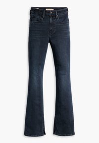 Vaqueros de campana de color azul oscuro con cintura alta, con un ligero desvanecimiento, dobladillo sin terminar y bolsillos delanteros. Hechos de denim con una textura suave.