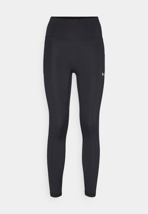 Leggings pretos de cintura alta feitos de um material suave e elástico. Apresentam costuras planas e um pequeno logo na parte inferior da perna direita.