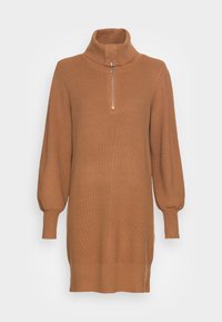 Robe en tricot camel marron à manches longues avec col montant et demi-zip sur le devant, poignets ajustés et texture côtelée.
