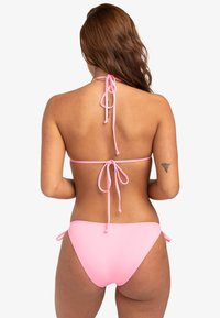 Rosa bikini-set med halterneck och knytning samt justerbara sidoknyt på underdelen. Slät textur, minimalistisk design.