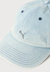 Ανοιχτό μπλε τζιν καπέλο μπέιζμπολ με καμπυλωτό γείσο και μικρό ασημένιο λογότυπο Puma στο κέντρο μπροστά.