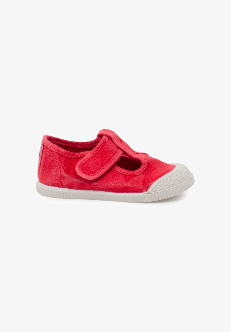 Chaussure en toile rouge pour enfants avec embout et semelle en caoutchouc blanc, dotée d'une fermeture à bride unique avec scratch.