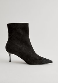 Black suede ankle boot with a pointed toe and stiletto heel, featuring a smooth texture and a fitted silhouette.