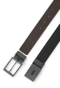 Deux ceintures : l'une en cuir texturé marron avec boucle en argent, l'autre en cuir noir lisse avec boucle en argent striée. Les deux ont plusieurs trous d'ajustement.