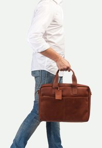 Bruine leren laptoptas met twee bovenhandvaten, voorvak en ritssluiting. Soepele textuur, rechthoekige vorm en gouden hardwareaccenten.