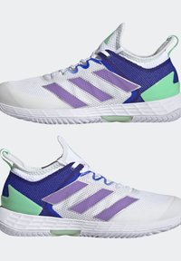 Białe buty sportowe z siateczkową cholewką, z fioletowymi trzema paskami brandingowymi, niebieskimi akcentami oraz zielonymi detalami na pięcie i języku.