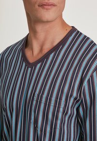 V-hals heren shirt met marineblauwe, lichtblauwe en roze verticale strepen. Heeft een voorkantzak en is gemaakt van zacht, textuurd katoen.