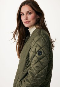 Gequilted olijfgroene bomberjack met een zachte textuur, geribbelde kraag en een zwart logo-opdruk op de linkermouw. Ritszakken aan de zijkant.