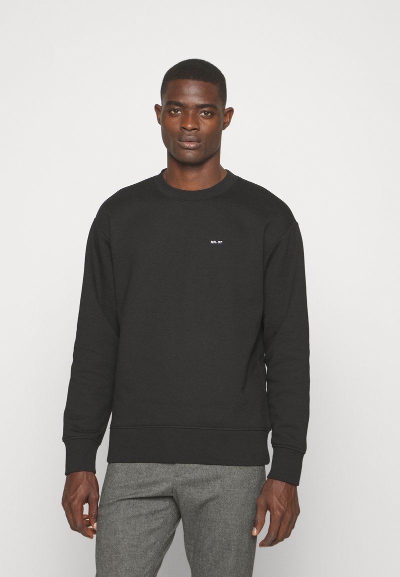 Zwarte sweatshirt met een ronde hals en ribgebreide manchetten, voorzien van een klein wit tekstlogo op de borst. Zacht materiaal, normale pasvorm.