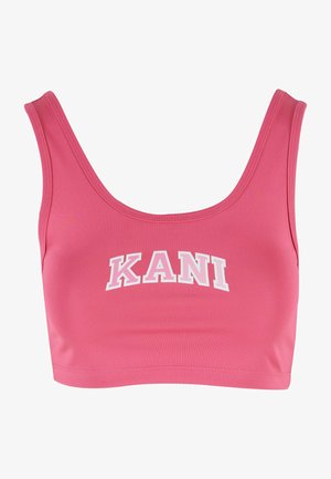 Różowy krótki top wykonany z gładkiego materiału, z szerokim dekoltem i grubymi ramiączkami, z napisem "KANI" wydrukowanym dużymi białymi literami z przodu.