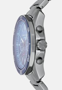 Zegarek ze stali nierdzewnej, z niebieskim pierścieniem, tarczami chronografu i textured niebieską tarczą. Posiada trzy przyciski i bransoletę ogniwową.