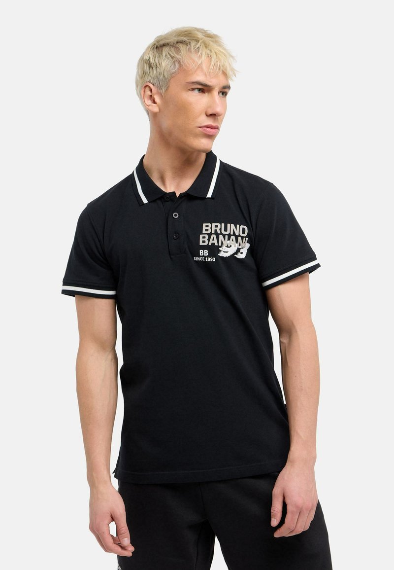 Sort polo skjorte med hvid trim, korte ærmer og krave. Har logo tekst på venstre side. Fremstillet af åndbart stof.