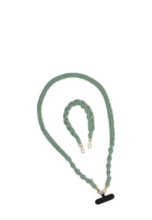 Set di accessori in corda macramè verde, composto da una lunga tracolla e un bracciale più corto, caratterizzati da hardware dorato e un design in fibra testurizzata.