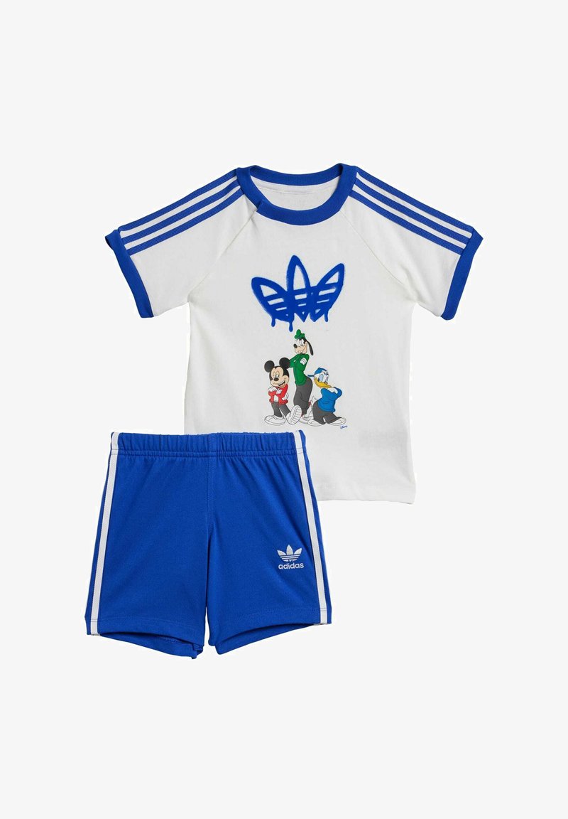 Completo per bambini Adidas costituito da una T-shirt bianca con dettagli blu, una grafica con tre caratteri, e pantaloni corti blu con strisce bianche e logo.