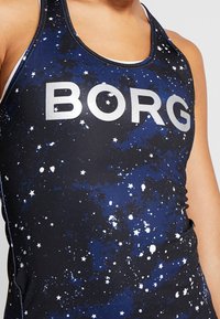 Musta hihaton paita, jossa on galaksiprintti sinisin ja valkoisin tähtikuvioin. "BORG" on kirjoitettu isoilla hopeisilla kirjaimilla rinnan kohdalla.