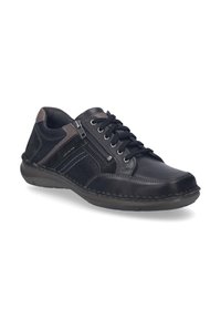 Zapatilla de piel negra y gris con cordones, cremallera lateral, detalles perforados y suela de goma; presenta texturas y costuras contrastantes.
