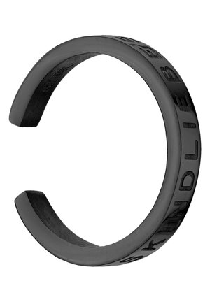 Bracelet manchette noir ouvert avec des lettres sombres gravées épelant "SKINDELBÆK" sur la surface extérieure.