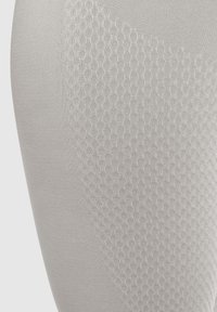 Lichtgrijze leggings met een gestructureerd honingraatpatroon aan één kant, een gladde afwerking in het algemeen, elastisch materiaal dat is ontworpen voor comfort en flexibiliteit.
