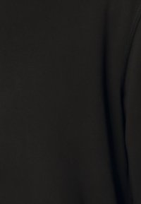 Tessuto nero che mostra una superficie liscia e una leggera lucentezza. Design semplice e privo di decorazioni, senza motivi o accessori visibili.