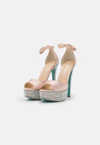 Scarpe con tacco alto e piatto in satin di colore nude, design open toe, e una base inferiore di un turchese scintillante e decorato con gemme.