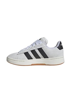Baskets basses blanches avec des rayures noires, des lacets blancs, une languette de talon noire et une semelle en gomme, vues de profil sur fond blanc.