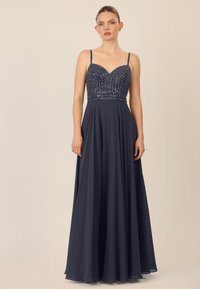 Navy Abendkleid mit Spaghetti-Trägern, besticktem Mieder, Herz-Ausschnitt und schwingendem Rock. Glatte Textur durchgehend.