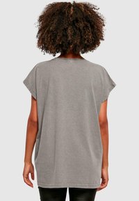 Šedé oversized tričko s krátkými rukávy, pohodlný design a jemná struktura. Má kulatý výstřih a rovný lem.