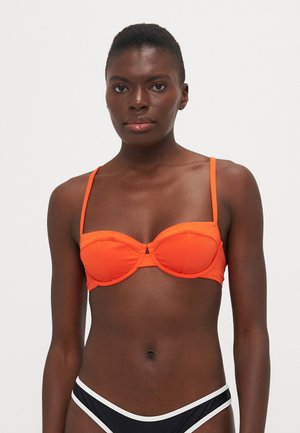 Orange bikini top with underwire construction, thin adjustable straps, and a center front keyhole detail. Smooth fabric texture.