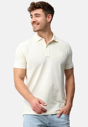 Lys beige polo skjorte med en blød tekstur, korte ærmer og en to-knaps placket. Har et subtilt logo på brystet.