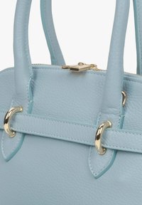 Jasnoniebieska skórzana torebka o teksturowym wykończeniu, z złotymi elementami, dwiema górnymi rączkami oraz zamknięciem na zamek.