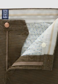 Bruine geruite broek met een koperen knoop en rits. Voering van lichte stof met blauwe stippen en dunne strepen. Afgewerkte randen zichtbaar.