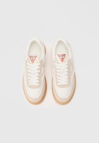 Sneakers bianchi e beige con una parte superiore in suede e pelle texture, suola in gomma spessa e un logo triangolare rosso sulla linguetta.
