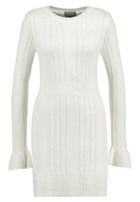 Abito in maglia bianco con scollatura aderente, maniche lunghe, texture a coste e polsini svasati. Le righe verticali aggiungono dettaglio e texture.