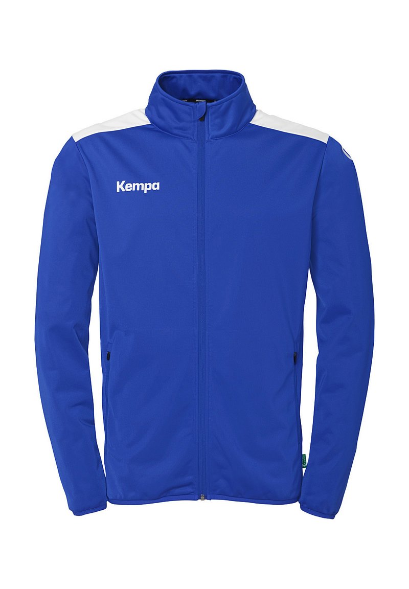 Blauwe sportjack met een hoge kraag, witte schouderaccenten en ritszakken aan de zijkant; voorzien van het "Kempa" logo in het wit op de linkerborst.