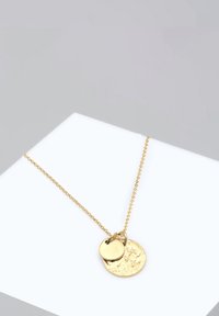 Collier en or avec une chaîne ornée de deux pendentifs circulaires, l'un texturé et plus grand, l'autre lisse et plus petit, pendent librement.