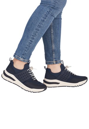 Marineblaue Sportschuhe mit einem Mesh-Obermaterial, verfügen über perforierte Einsätze, eine cremefarbene Zwischensohle und eine strukturierte schwarze Gummisohle. Die Schnürsenkel sind weiß.