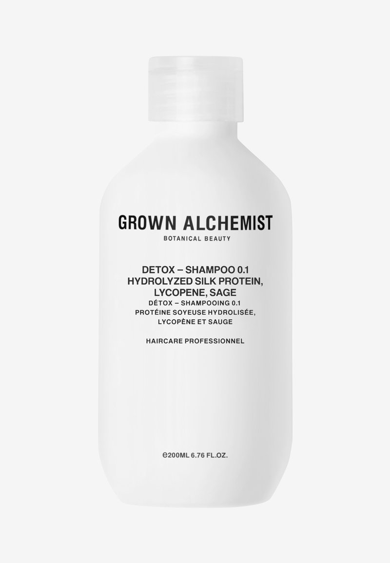 Witte plastic fles met shampoo, gelabeld "GROWN ALCHEMIST," met zwarte tekst. Bevat kruiden ingrediënten: zijde proteïne, lycopeen, salie.