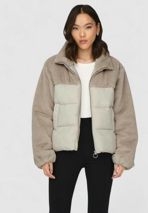 Puffjacka med en delad design, med plyschtaupefleece ovanpå och slät, ljusgrått tyg nedanför; frontdragkedja och sidofickor.