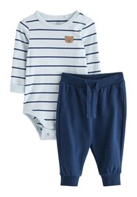 Body en bleu clair rayé avec graphique ours et joggers en coton bleu marine. Fermetures à pression sur le body et poignets côtelés sur le pantalon.