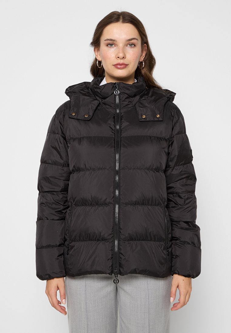 Schwarze Winterjacke mit Reißverschluss auf der Vorderseite, abnehmbarem Kapuze und Druckknopfdetails. Mit horizontal gestepptem Design und zwei seitlichen Taschen.