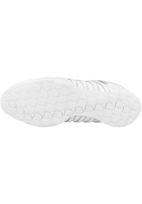 Weißer Sneaker mit einer strukturierten Gummisohle und einer glatten Ferse. Verfügt über mehrere Rillen für Griffigkeit und ein minimalistisches Design.