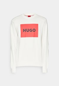 Felpa bianca con un grafico rettangolare rosso contenente la parola "HUGO" in grassetto nero. Maniche lunghe e polsini a coste.