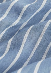 Blauw-wit gestreepte stof, met een lichte, luchtige textuur en duidelijke horizontale lijnen. Gemaakt van een lichtgewicht materiaal.