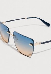 Gafas de sol cuadradas con lentes de degradado azul a beige, detalles en dorado y varillas delgadas de color azul oscuro para una comodidad ligera.