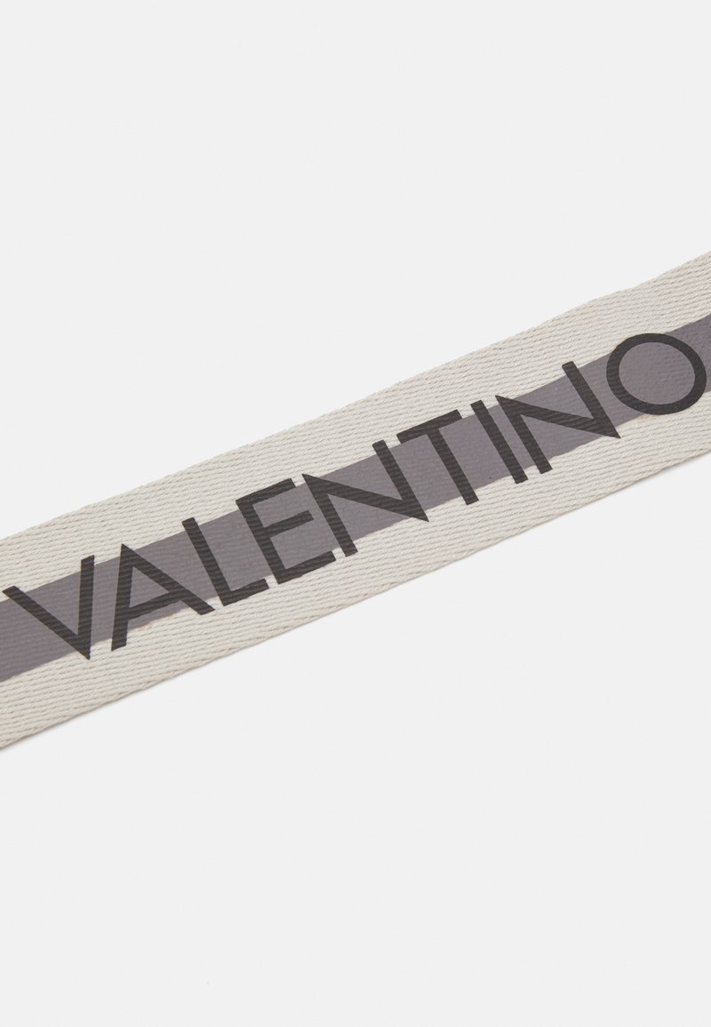 Nastro di stoffa beige con una striscia grigio scuro e "VALENTINO" stampato in caratteri in grassetto, con una superficie testurizzata e bordi dritti.