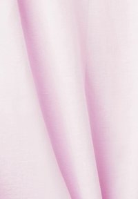 Tissu rose clair doux avec des plis délicats et une texture lisse visible en gros plan.