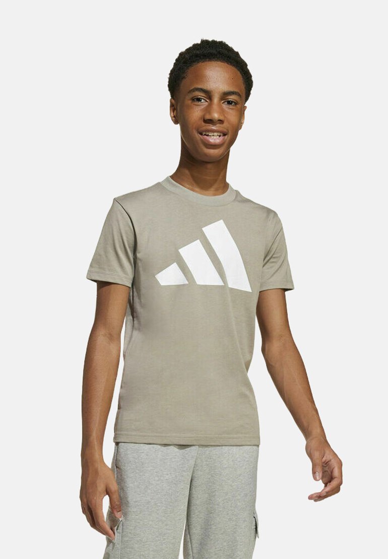 T-shirt in cotone marrone chiaro con un grande logo Adidas bianco. Presenta un collo a giro, maniche corte e un design aderente.